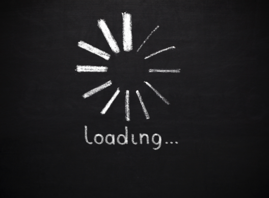 Un cercle de segments blancs dessinés à la craie formant une roue de chargement sur un fond ardoise noire, avec le texte exact 'Loading...' écrit en dessous.