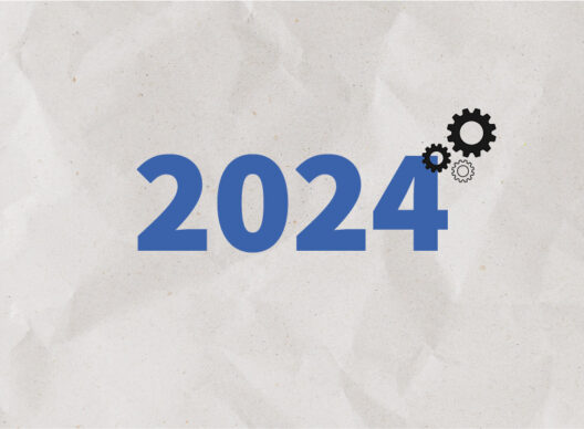 Chiffre 2024 en bleu sur fond papier froissé avec trois engrenages noirs, symbolisant la technologie et l'innovation